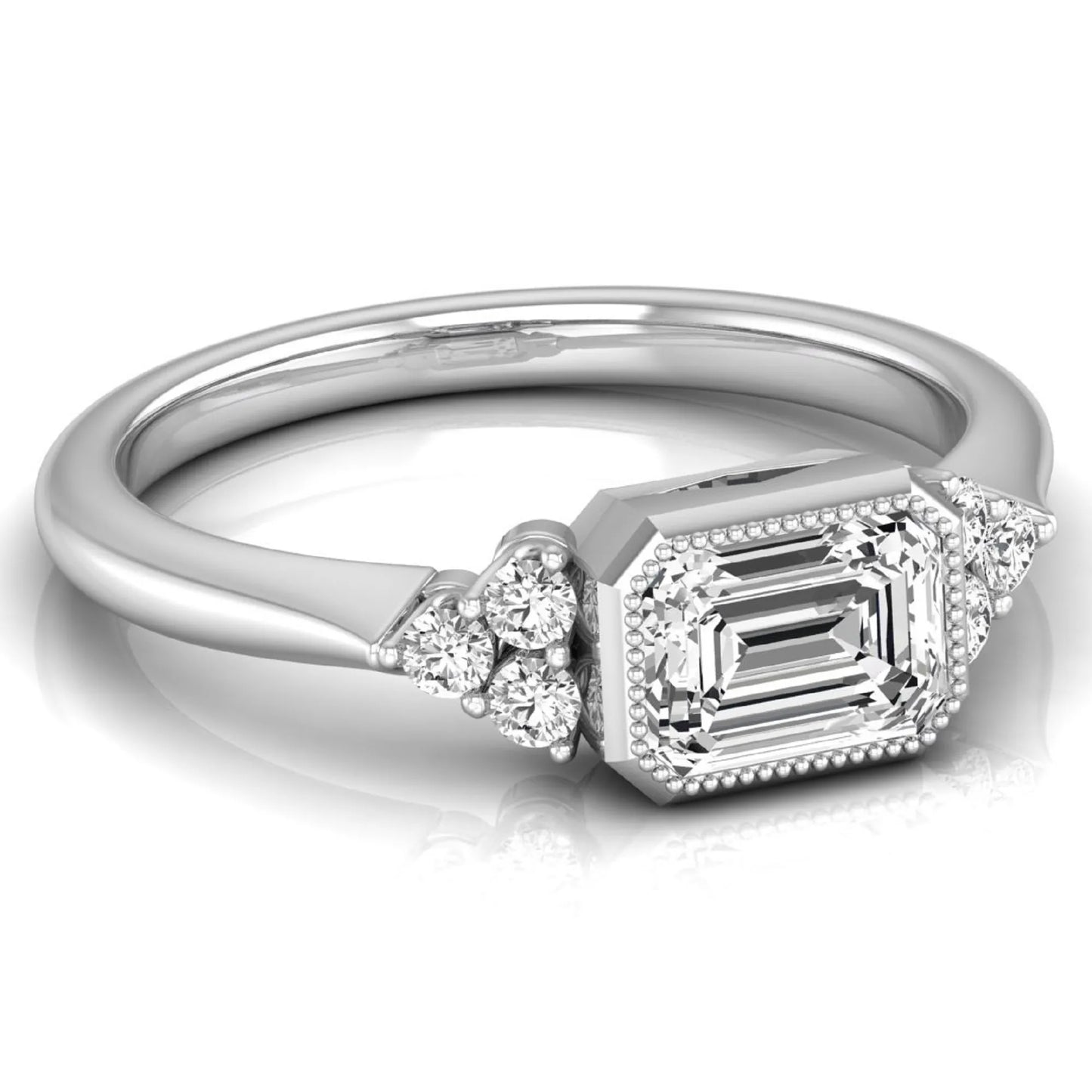 Emerald cut lab grown diamond engagement ring featuring a milgrain bezel setting with round side stone clusters in white gold.