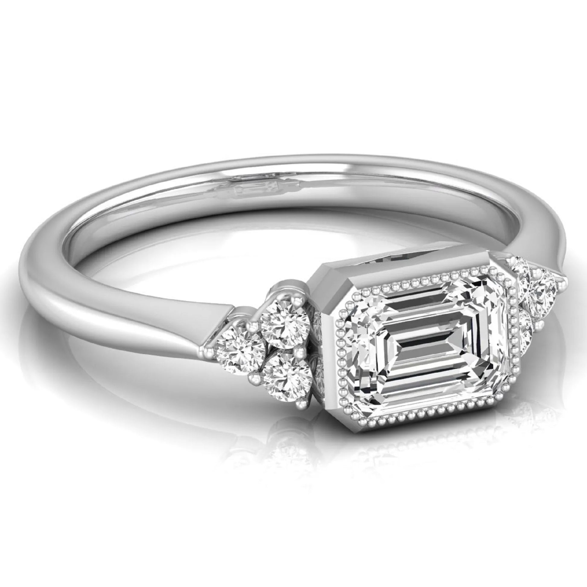 Emerald cut lab grown diamond engagement ring featuring a milgrain bezel setting with round side stone clusters in white gold.