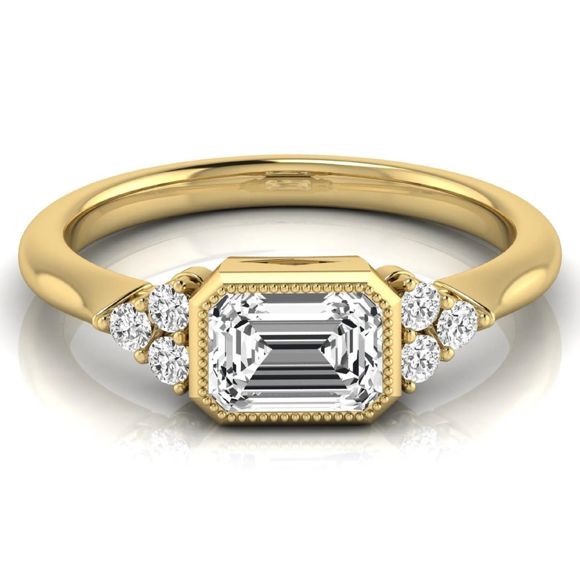 Emerald cut lab grown diamond engagement ring featuring a milgrain bezel setting with round side stone clusters in yellow gold.