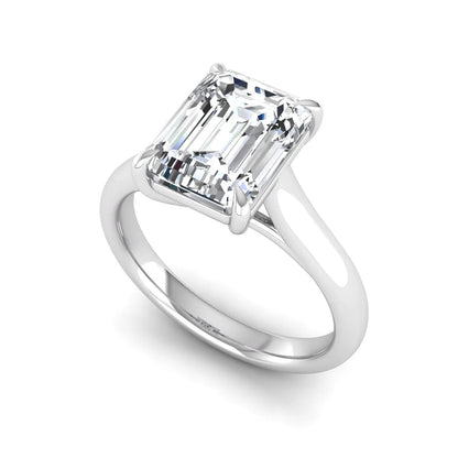 Emerald cut lab grown diamond solitaire engagement ring with a four-prong setting and polished tapered white gold band.