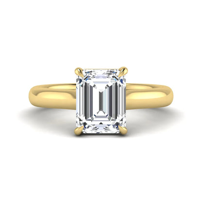 Emerald cut lab grown diamond solitaire engagement ring with a four-prong setting and polished tapered yellow gold band.