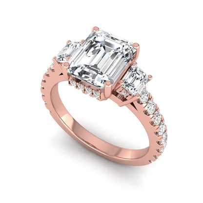 Emerald cut three stone lab grown diamond engagement ring in rose gold featuring a 2.62 carat IGI certified center diamond with emerald cut side stones and pavé band.