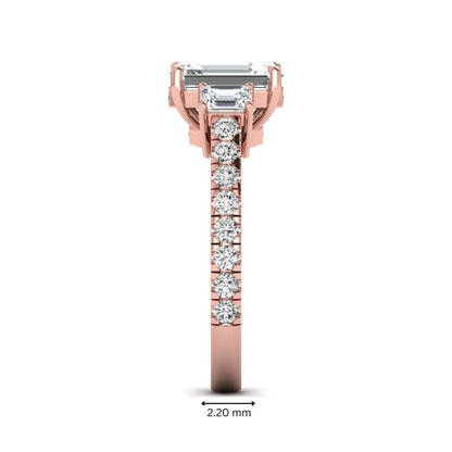 Emerald cut three stone lab grown diamond engagement ring in rose gold featuring a 2.62 carat IGI certified center diamond with emerald cut side stones and pavé band.