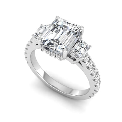 Emerald cut three stone lab grown diamond engagement ring in white gold featuring a 2.62 carat IGI certified center diamond with emerald cut side stones and pavé band.