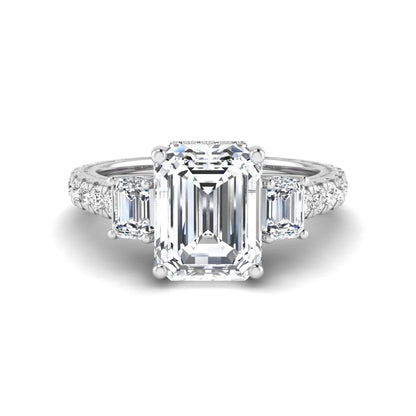 Emerald cut three stone lab grown diamond engagement ring in white gold featuring a 2.62 carat IGI certified center diamond with emerald cut side stones and pavé band.