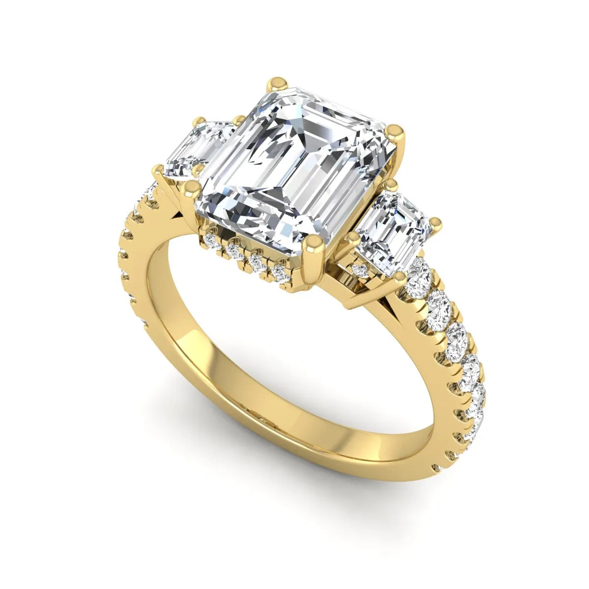 Emerald cut three stone lab grown diamond engagement ring in yellow gold featuring a 2.62 carat IGI certified center diamond with emerald cut side stones and pavé band.