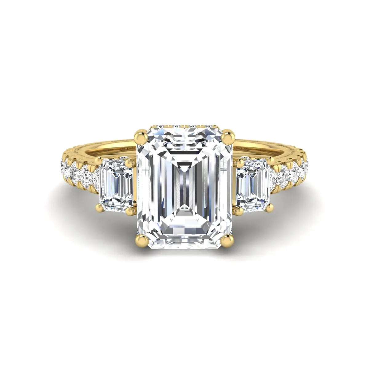 Emerald cut three stone lab grown diamond engagement ring in yellow gold featuring a 2.62 carat IGI certified center diamond with emerald cut side stones and pavé band.