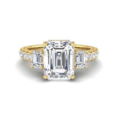 Emerald cut three stone lab grown diamond engagement ring in yellow gold featuring a 2.62 carat IGI certified center diamond with emerald cut side stones and pavé band.