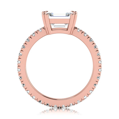 Emerald cut lab grown diamond side stone engagement ring featuring a four-prong setting with round accent diamonds in a rose gold tone design.