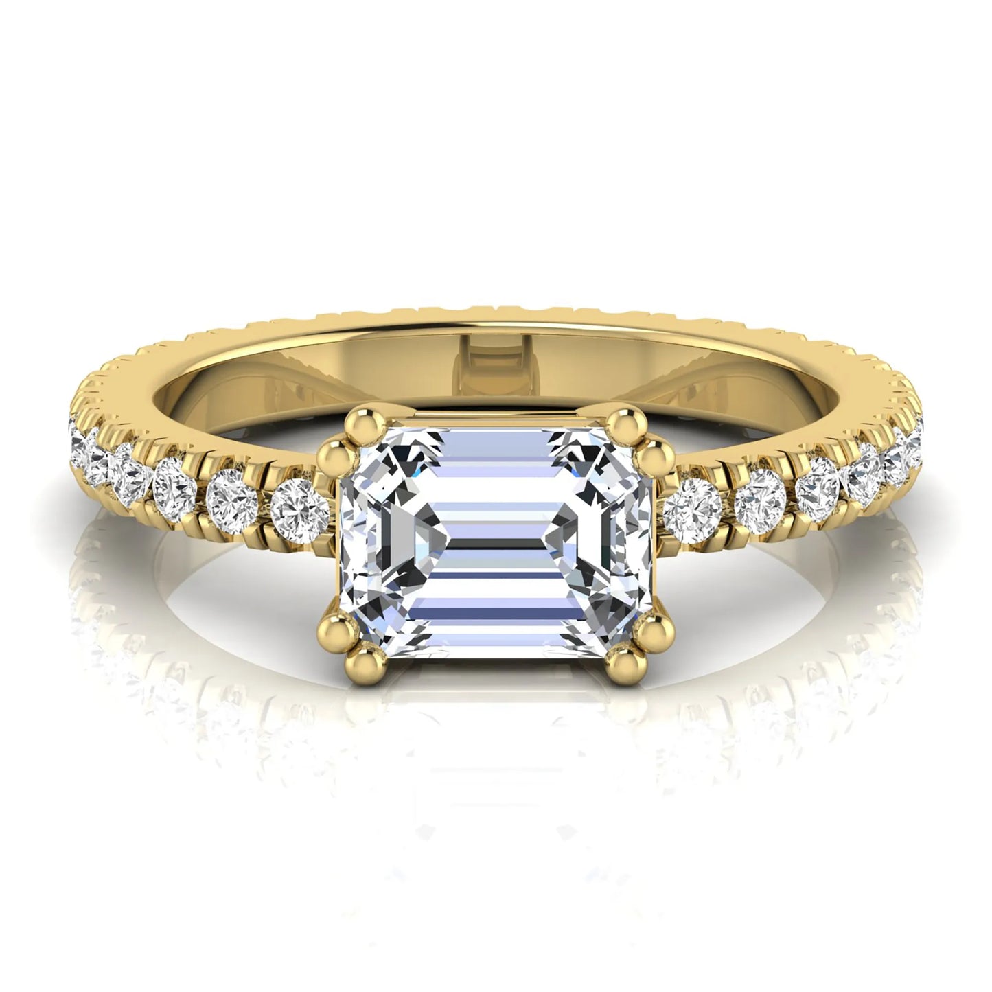 Emerald cut lab grown diamond side stone engagement ring featuring a four-prong setting with round accent diamonds in a yellow gold tone design.