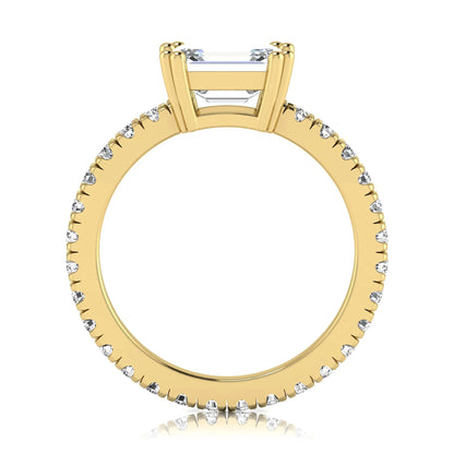 Emerald cut lab grown diamond side stone engagement ring featuring a four-prong setting with round accent diamonds in a yellow gold tone design.