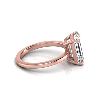 Emerald cut lab grown diamond solitaire engagement ring with a four prong setting in a rose gold tone, featuring an IGI certified 3.01 carat center diamond.