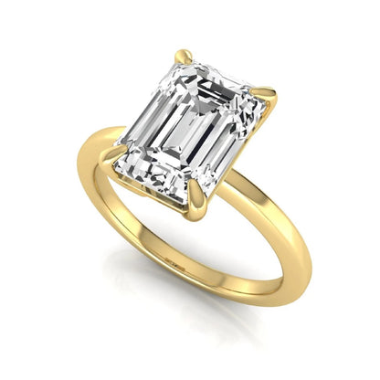 Emerald cut lab grown diamond solitaire engagement ring with a four prong setting in a yellow gold tone, featuring an IGI certified 3.01 carat center diamond.