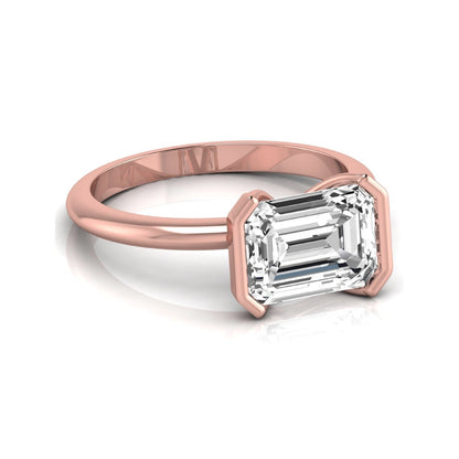 Emerald cut lab grown diamond engagement ring featuring a 5.00 carat center diamond in a modern half bezel solitaire setting with a polished rose gold tone band.