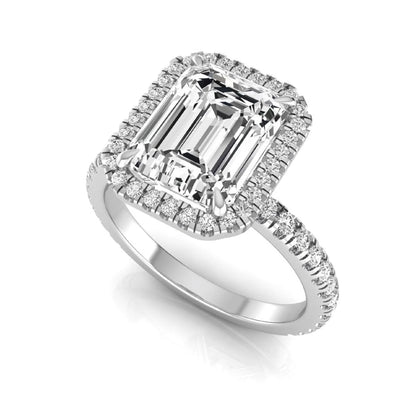 Emerald cut lab grown diamond engagement ring featuring a round diamond halo, pavé accent band, and four-prong setting with a polished white gold tone band.