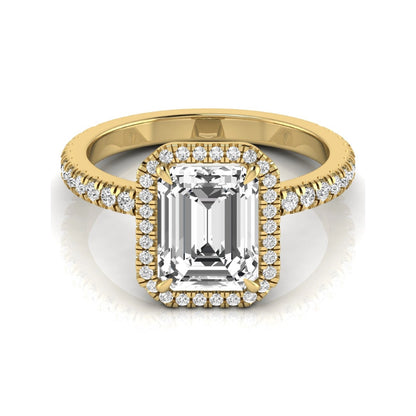 Emerald cut lab grown diamond engagement ring featuring a round diamond halo, pavé accent band, and four-prong setting with a polished yellow gold tone band.