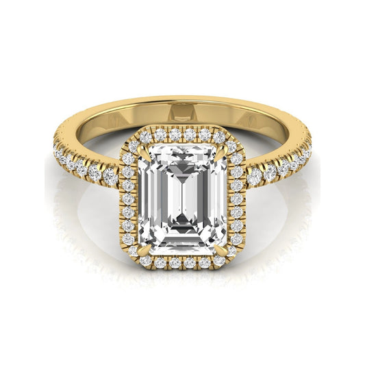 Emerald cut lab grown diamond engagement ring featuring a round diamond halo, pavé accent band, and four-prong setting with a polished yellow gold tone band.