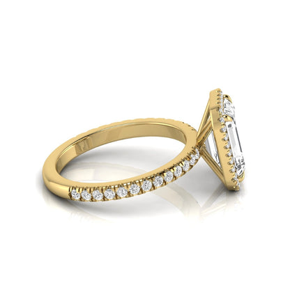 Emerald cut lab grown diamond engagement ring featuring a round diamond halo, pavé accent band, and four-prong setting with a polished yellow gold tone band.