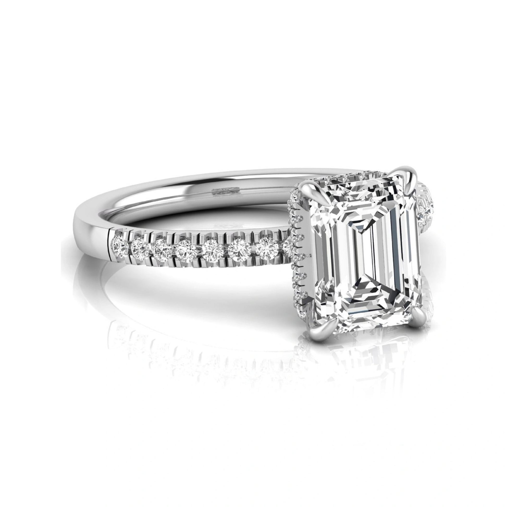 Emerald cut lab grown diamond engagement ring featuring a hidden halo, pavé diamond band, and four-prong setting in white gold tone.