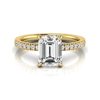 Emerald cut lab grown diamond engagement ring featuring a hidden halo, pavé diamond band, and four-prong setting in yellow gold tone.