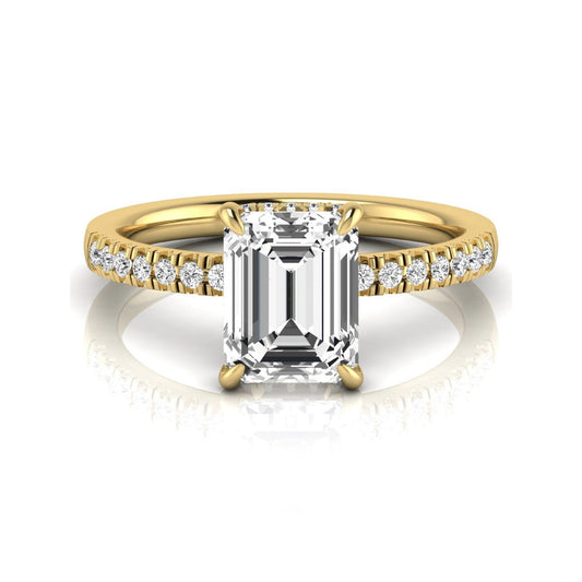 Emerald cut lab grown diamond engagement ring featuring a hidden halo, pavé diamond band, and four-prong setting in yellow gold tone.