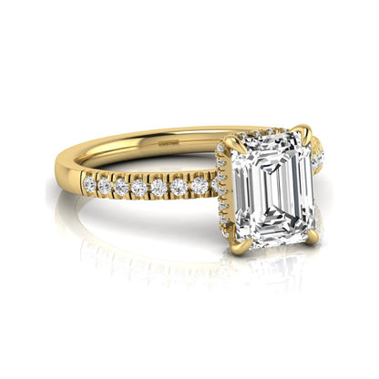 Emerald cut lab grown diamond engagement ring featuring a hidden halo, pavé diamond band, and four-prong setting in yellow gold tone.
