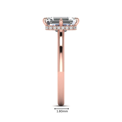 Emerald cut lab grown diamond hidden halo solitaire engagement ring featuring a four-prong setting on a polished rose gold band.