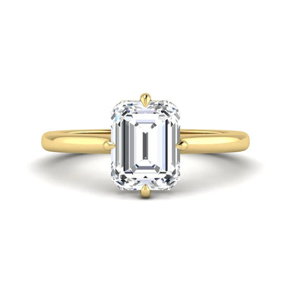 Emerald cut lab grown diamond hidden halo solitaire engagement ring featuring a four-prong setting on a polished yellow gold band.