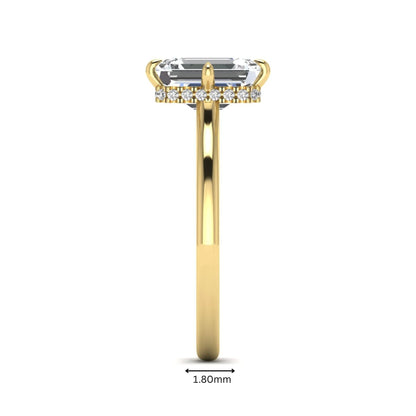 Emerald cut lab grown diamond hidden halo solitaire engagement ring featuring a four-prong setting on a polished yellow gold band.