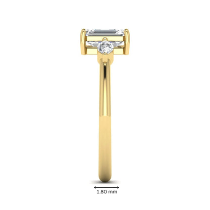 Emerald cut three stone lab grown diamond engagement ring featuring a 1.06 carat IGI certified center diamond with marquise side diamonds in yellow gold.