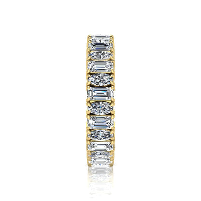 Emerald and oval cut lab grown diamond eternity band ring with alternating diamonds in a shared prong setting and yellow gold style.