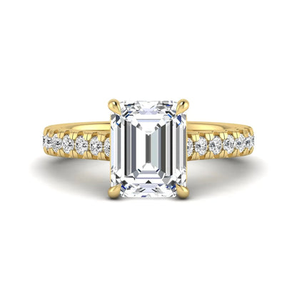 Emerald cut lab grown diamond engagement ring with pavé round diamonds in a yellow gold four-prong cathedral setting