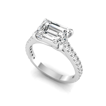 Emerald cut lab grown diamond solitaire engagement ring featuring a four-prong setting with a pavé diamond band in white gold tone.