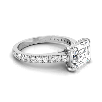 Emerald cut lab grown diamond solitaire engagement ring featuring a four-prong setting with a pavé diamond band in white gold tone.