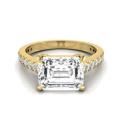 Emerald cut lab grown diamond solitaire engagement ring featuring a four-prong setting with a pavé diamond band in yellow gold tone.
