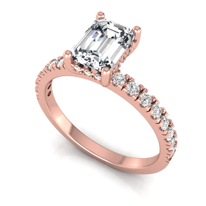 Emerald cut lab grown diamond solitaire ring with round pavé side stones in a four-prong setting and polished rose gold finish.