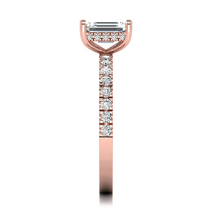 Emerald cut lab grown diamond solitaire ring with round pavé side stones in a four-prong setting and polished rose gold finish.