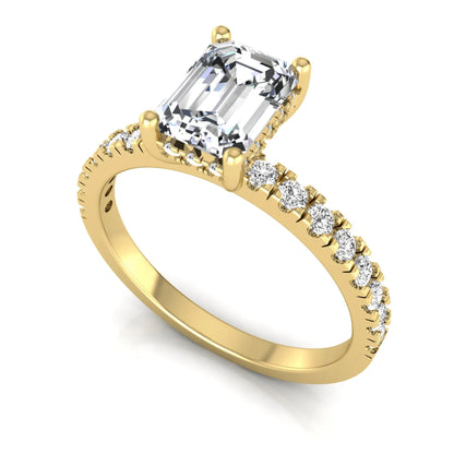 Emerald cut lab grown diamond solitaire ring with round pavé side stones in a four-prong setting and polished yellow gold finish.
