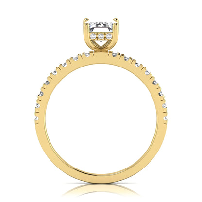 Emerald cut lab grown diamond solitaire ring with round pavé side stones in a four-prong setting and polished yellow gold finish.