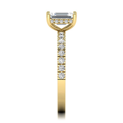Emerald cut lab grown diamond solitaire ring with round pavé side stones in a four-prong setting and polished yellow gold finish.