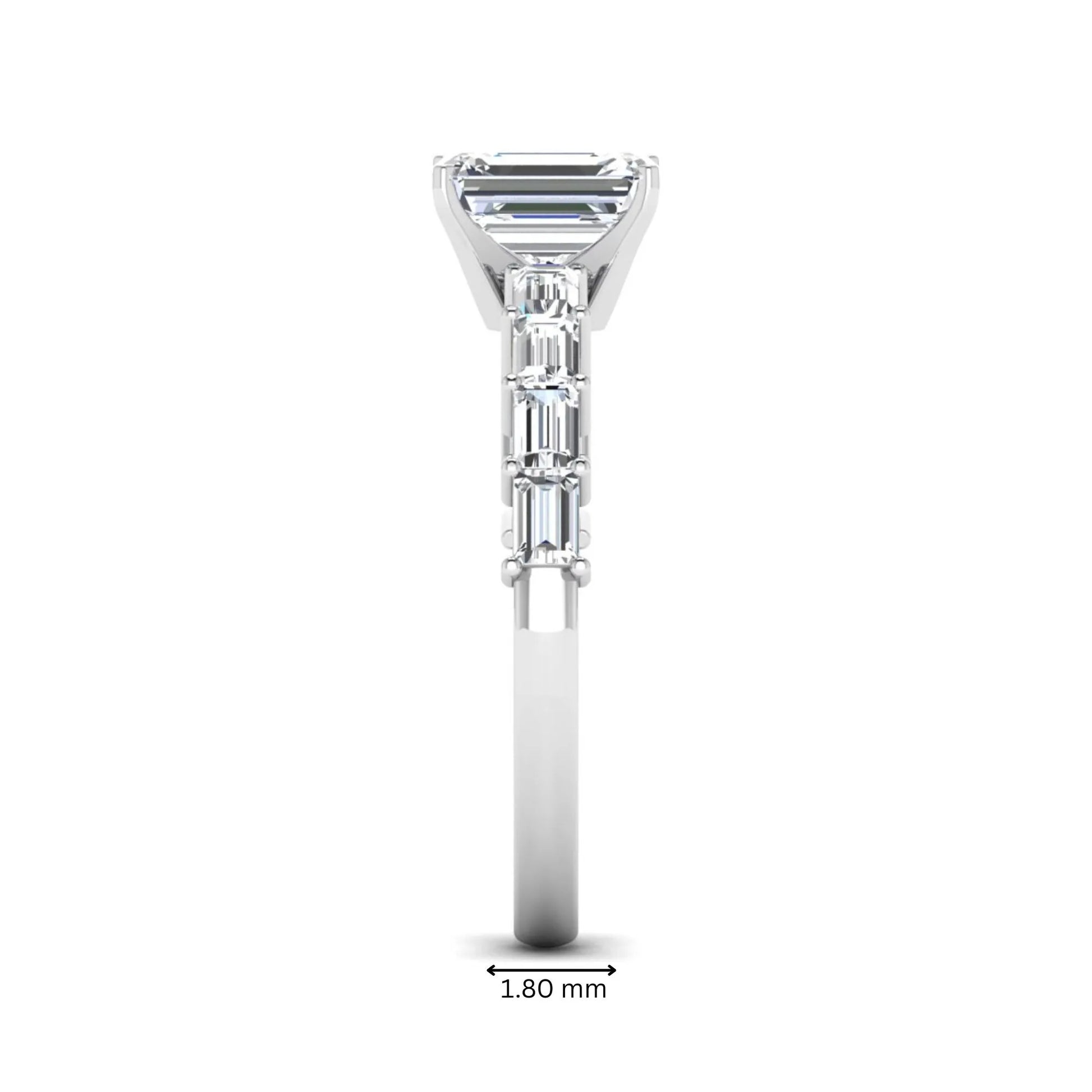 Emerald cut lab grown diamond engagement ring with baguette side diamonds in a four-prong solitaire accent setting and white gold tone band.