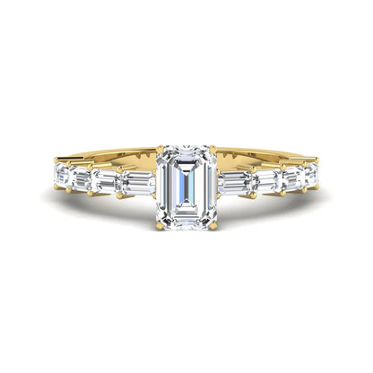 Emerald cut lab grown diamond engagement ring with baguette side diamonds in a four-prong solitaire accent setting and yellow gold tone band.
