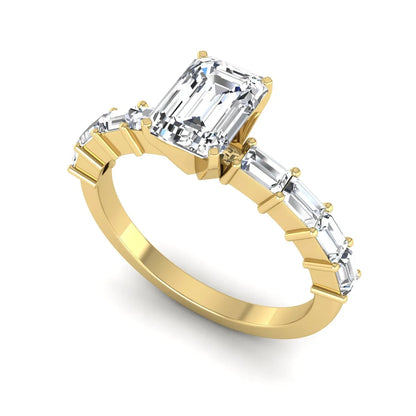 Emerald cut lab grown diamond engagement ring with baguette side diamonds in a four-prong solitaire accent setting and yellow gold tone band.