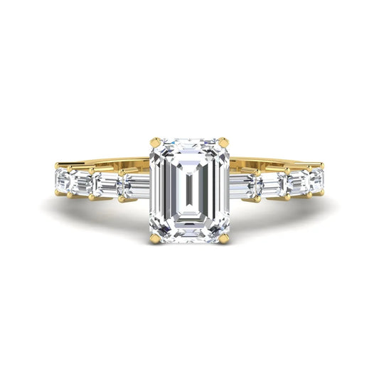 Emerald cut lab grown diamond engagement ring with baguette side diamonds in a four-prong solitaire accent setting and yellow gold tone band.