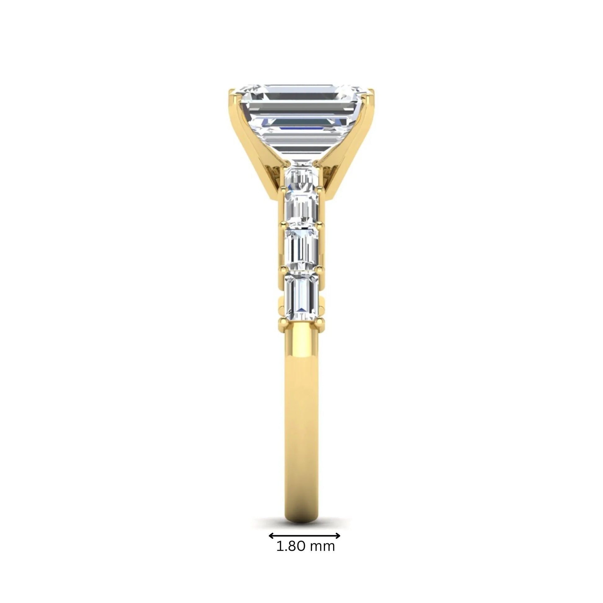 Emerald cut lab grown diamond engagement ring with baguette side diamonds in a four-prong solitaire accent setting and yellow gold tone band.