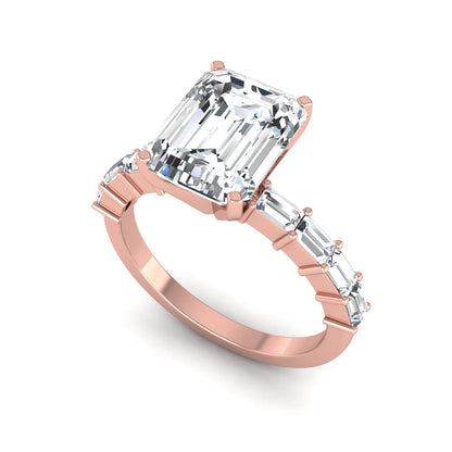 Emerald cut lab grown diamond engagement ring with baguette side diamonds in a four-prong solitaire accent setting and rose gold tone band.