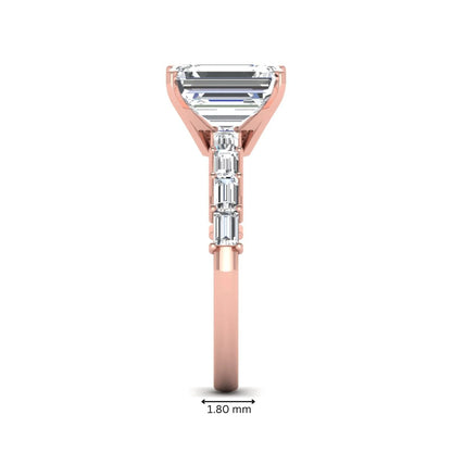 Emerald cut lab grown diamond engagement ring with baguette side diamonds in a four-prong solitaire accent setting and rose gold tone band.