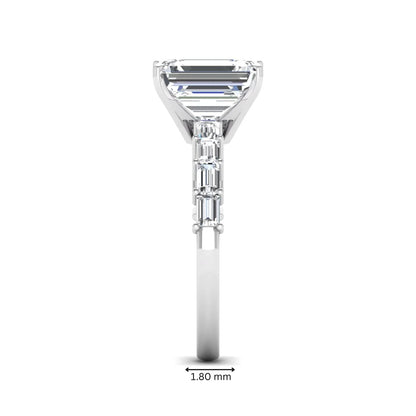 Emerald cut lab grown diamond engagement ring with baguette side diamonds in a four-prong solitaire accent setting and white gold tone band.