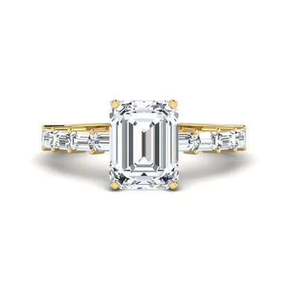 Emerald cut lab grown diamond engagement ring with baguette side diamonds in a four-prong solitaire accent setting and yellow gold tone band.