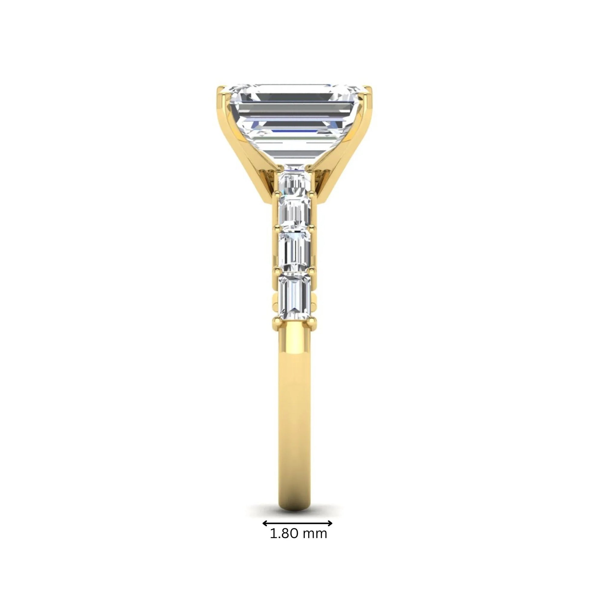 Emerald cut lab grown diamond engagement ring with baguette side diamonds in a four-prong solitaire accent setting and yellow gold tone band.
